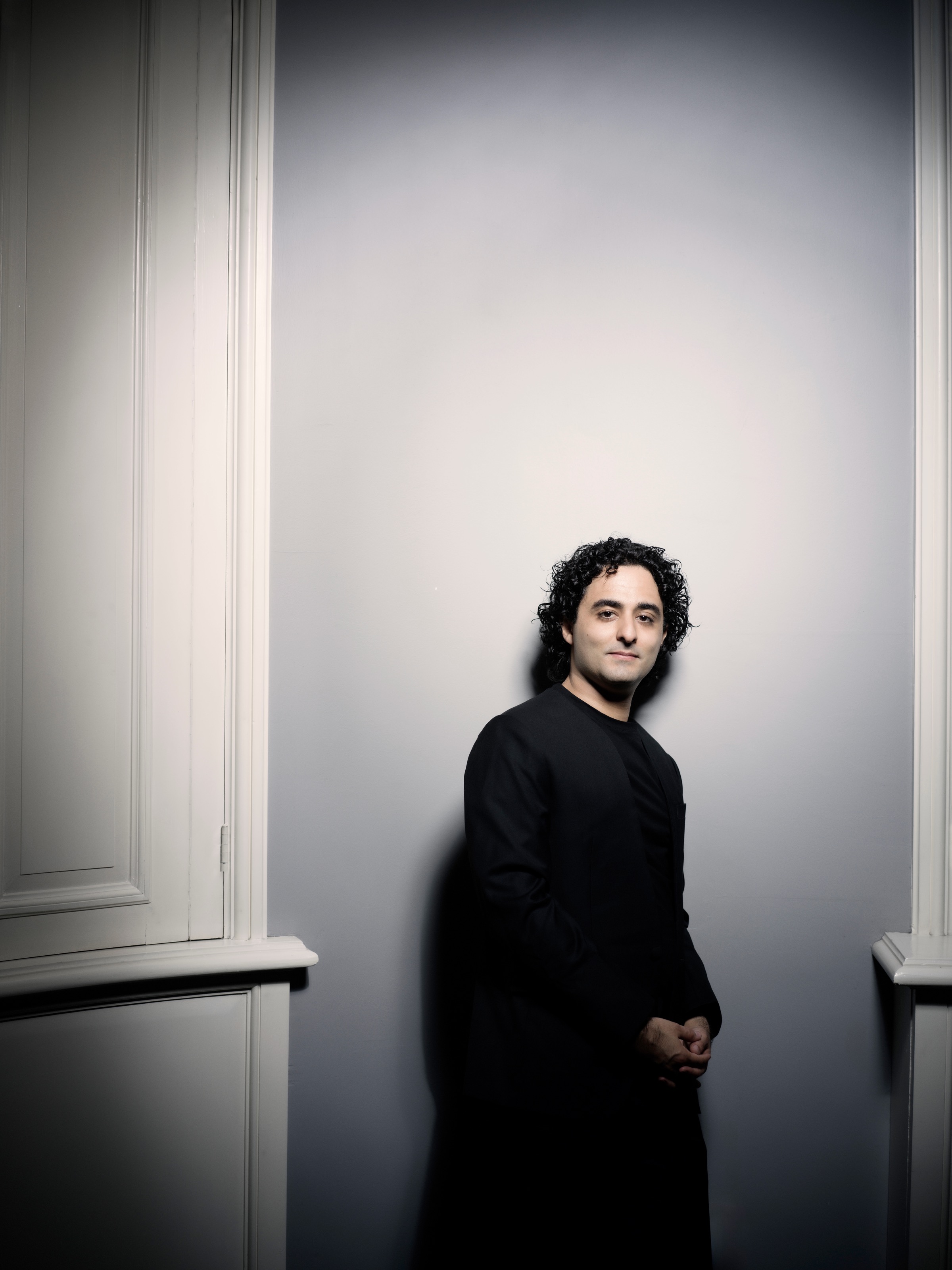 Kerem Hasan standing beside pale architectural panelling